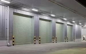 Shutter door or roller door and concrete floor outside factory building use for industrial background. Shutter door or roller door and concrete floor outside factory building use for industrial background.