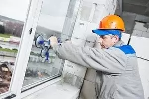 male industrial builder worker at window installation in building construction site male industrial builder worker at window installation in building construction site