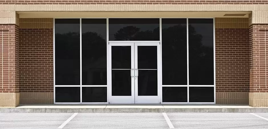 A new unoccupied generic store front, business or professional office space in a contemporary strip mall. Red brick with dark tinted windows in brushed aluminum frames and a double door. A new unoccupied generic store front, business or professional office space in a contemporary strip mall. Red brick with dark tinted windows in brushed aluminum frames and a double door.