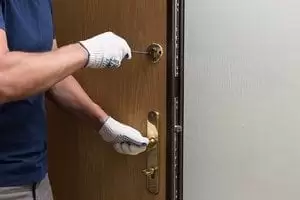 Man fixing the door with screwdriver Man fixing the door with screwdriver
